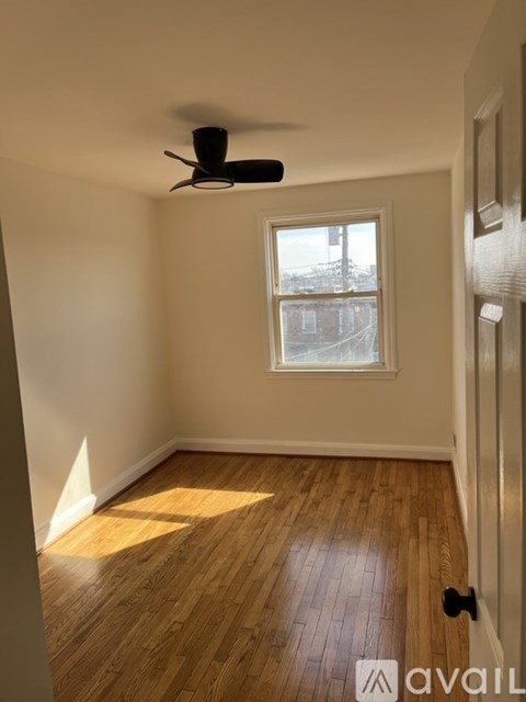 A room with a ceiling fan and a window.