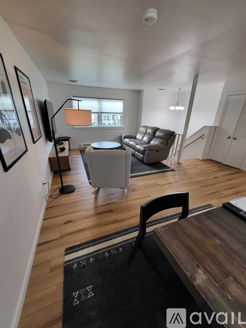 A living room with a grey couch and a black chair.