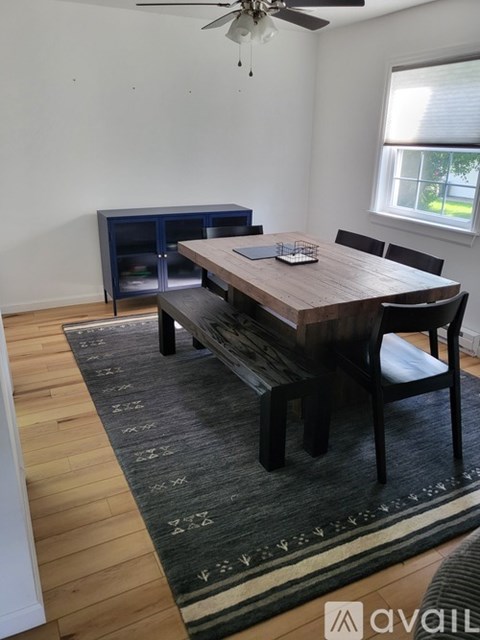 A dining room with a wooden table and chairs.