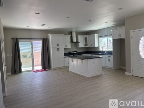 A spacious kitchen with white cabinets and a black countertop.