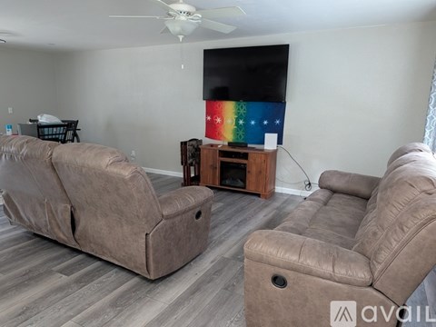 A living room with a brown couch and a television.