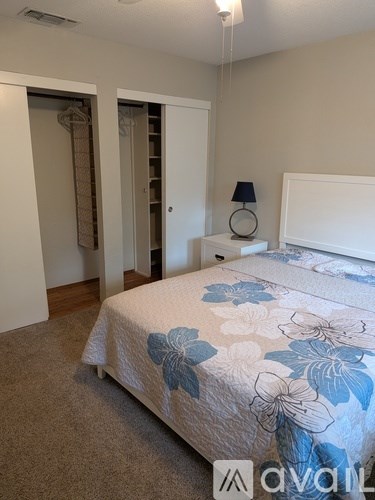 A bedroom with a bed, nightstand, and lamp.