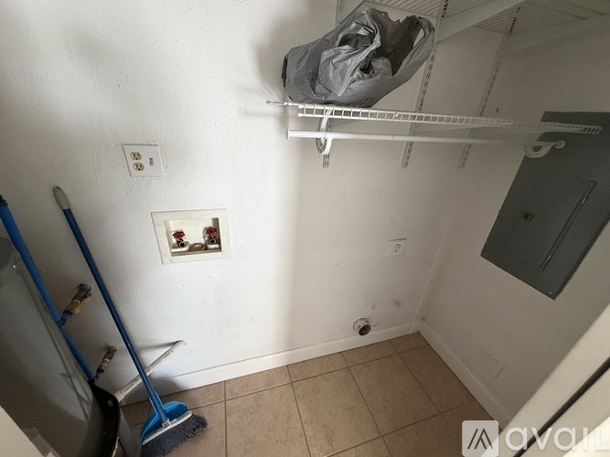 A room with a broom and a mop on the floor.