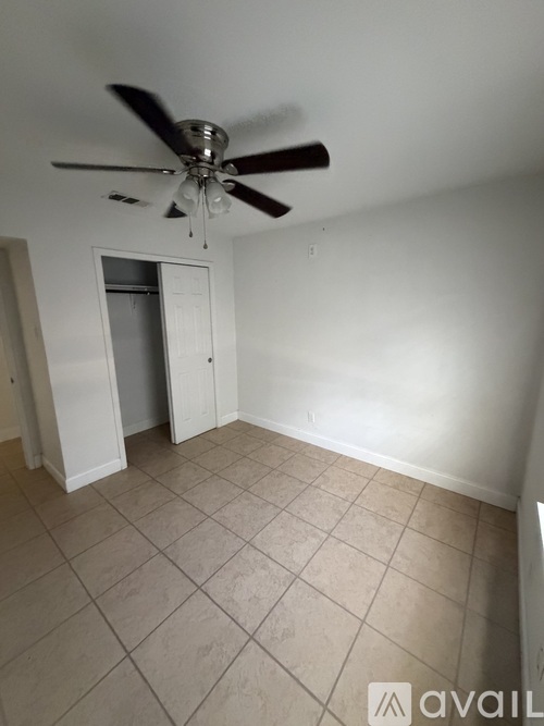 A room with a ceiling fan and tile flooring.
