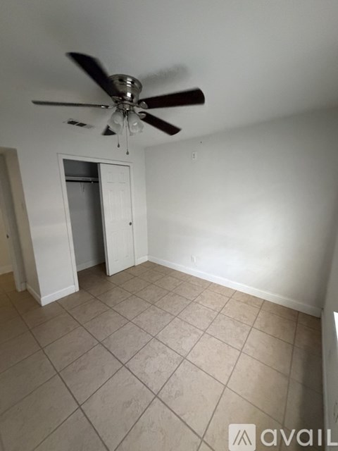 A room with a ceiling fan and tile flooring.