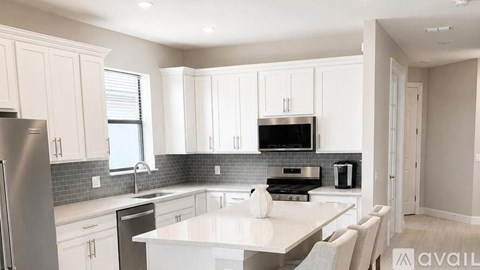 A modern kitchen with white cabinets and a large island.