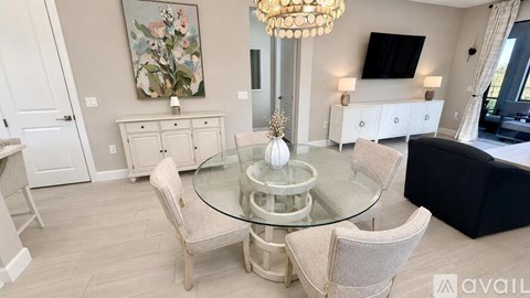 A modern living room with a glass table and chairs.