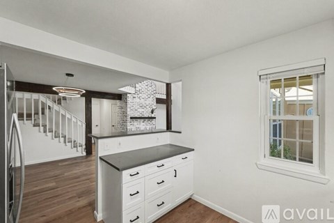 A kitchen with white cabinets and a black countertop.