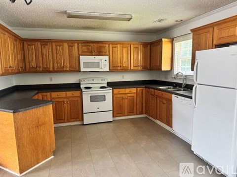 A kitchen with wooden cabinets and white appliances.