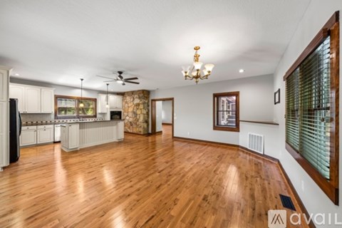 A spacious room with wooden floors and a ceiling fan.