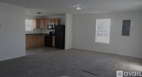 A room with wooden flooring and a window letting in sunlight.