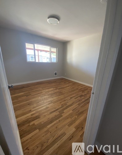 A room with wooden flooring and a window.