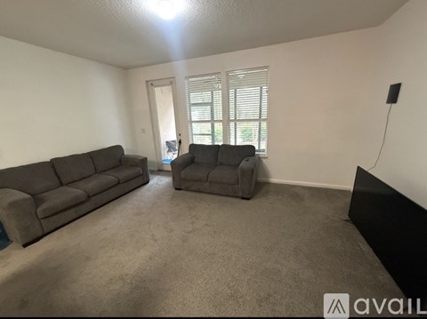A living room with a grey sofa and a grey armchair.