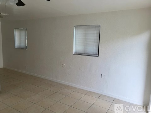 A room with a fan and two windows.