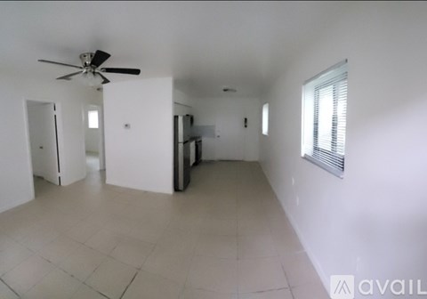 A spacious room with a ceiling fan and tiled flooring.