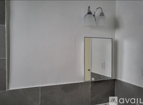 A bathroom with a mirror and two lights on the wall.