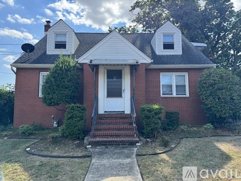 A red brick house with a white door and a small porch.