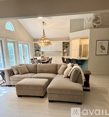A living room with a beige sofa and ottoman.