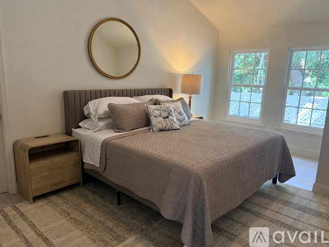 A bedroom with a bed, nightstand, and lamp.
