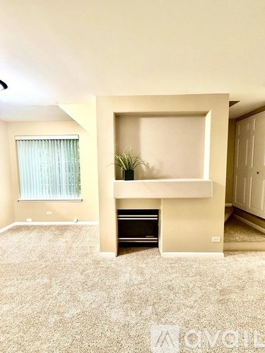A living room with a fireplace and a plant on the mantle.
