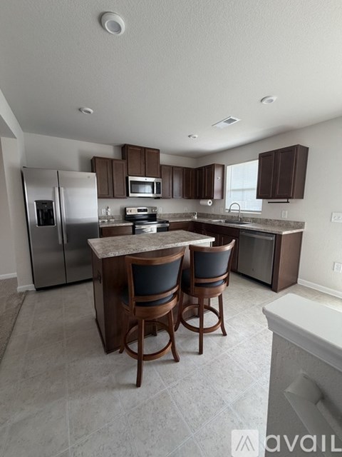 A kitchen with a table and chairs.