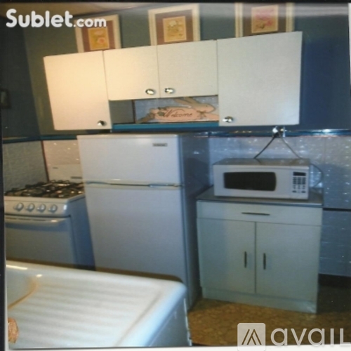 A kitchen with white appliances and cabinets.