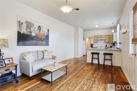 A living room with a grey couch and a wooden floor.