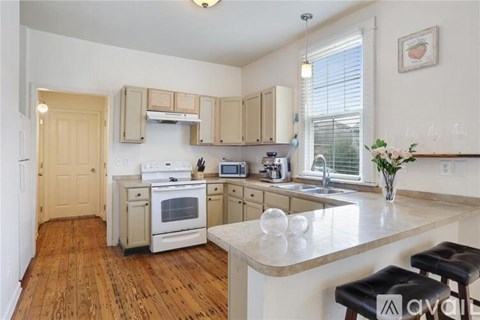 A kitchen with wooden floors and white walls.