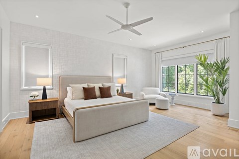 A bedroom with a large bed and a ceiling fan.