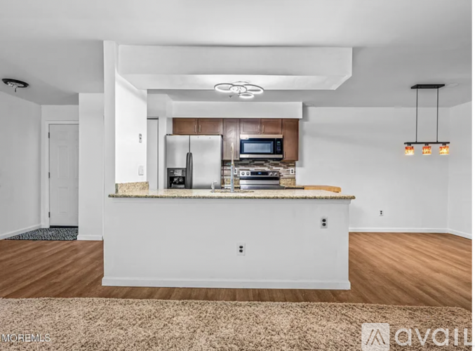 A kitchen with a white countertop and a microwave above it.