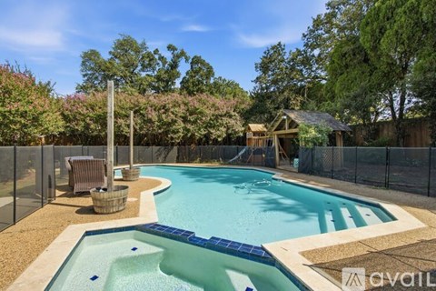 A pool surrounded by a fence and trees.