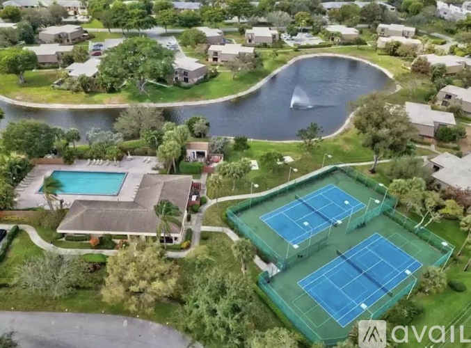 A bird's eye view of a residential area with a tennis court and a pool.