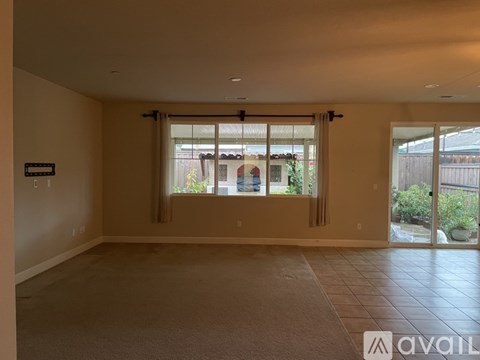 A spacious room with a carpeted floor and sliding glass doors.