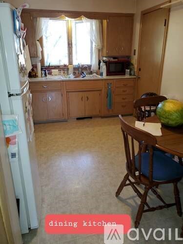 A kitchen with a table and chairs in front of it.