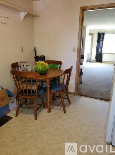 A dining room with a wooden table and chairs.