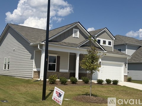 A house with a sign in front of it that says "For Sale".