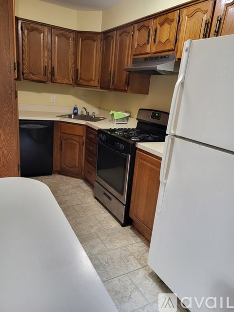 A kitchen with wooden cabinets and a white refrigerator.