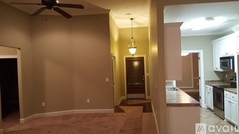 A living room with a ceiling fan and a light hanging from the ceiling.