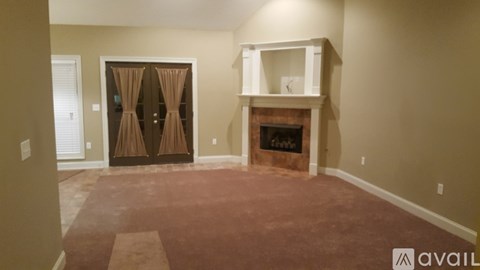 A room with a fireplace and a large window with curtains.