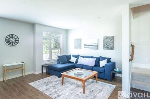 A living room with a blue couch and a wooden coffee table.