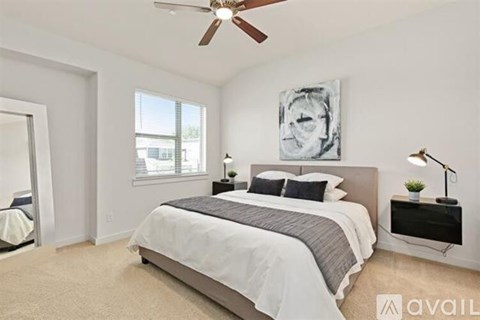 A bedroom with a large bed and a ceiling fan.