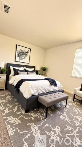 A bedroom with a large bed and a bench in front of it.