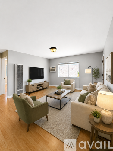 A living room with a green armchair, a white sofa, and a wooden coffee table.