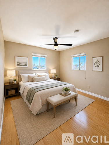A bedroom with a bed, a bench, and a ceiling fan.