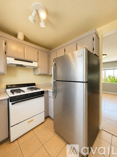 A kitchen with a stove top oven and a refrigerator.