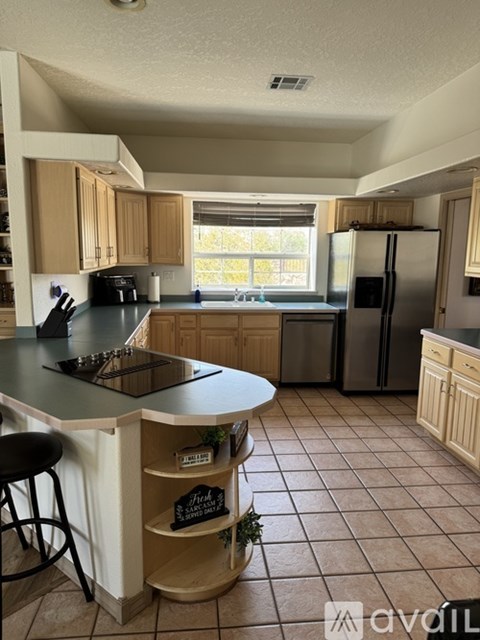 A kitchen with a black counter top and wooden cabinets.