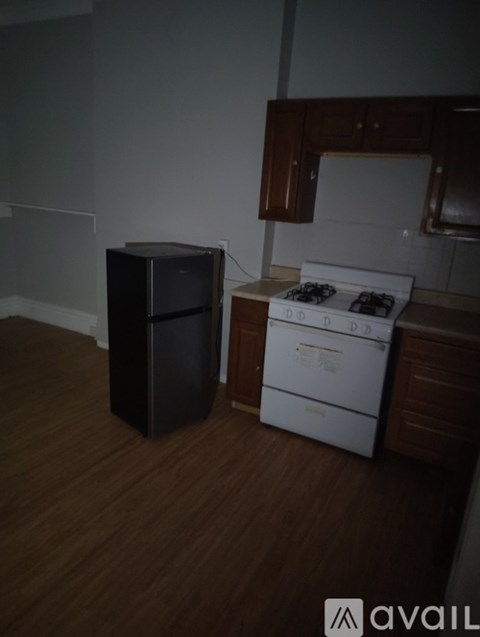 A kitchen with a white stove and a black microwave.
