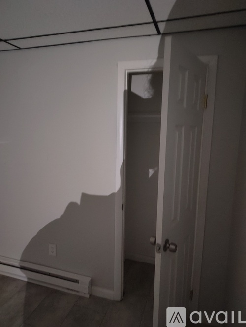 A white door is open to a dark hallway.