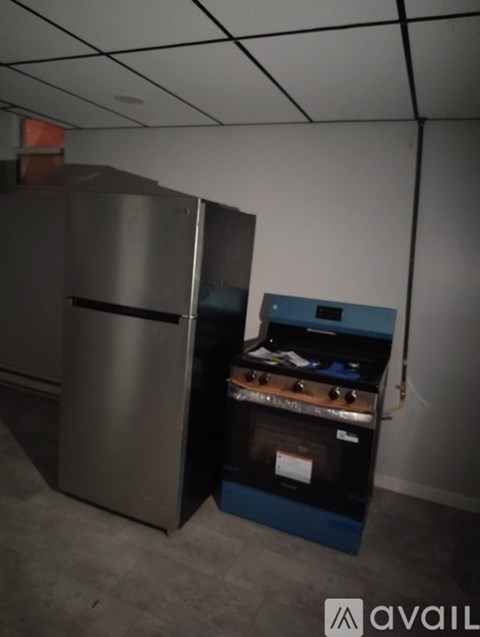 A stainless steel refrigerator and a blue oven in a room.