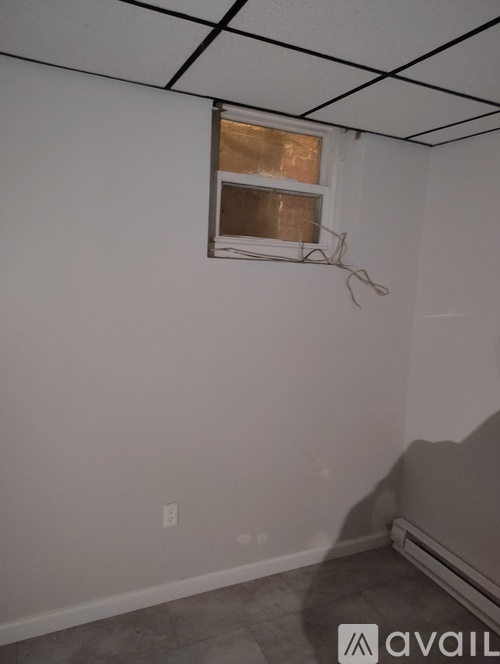A room with a window and a wall socket.